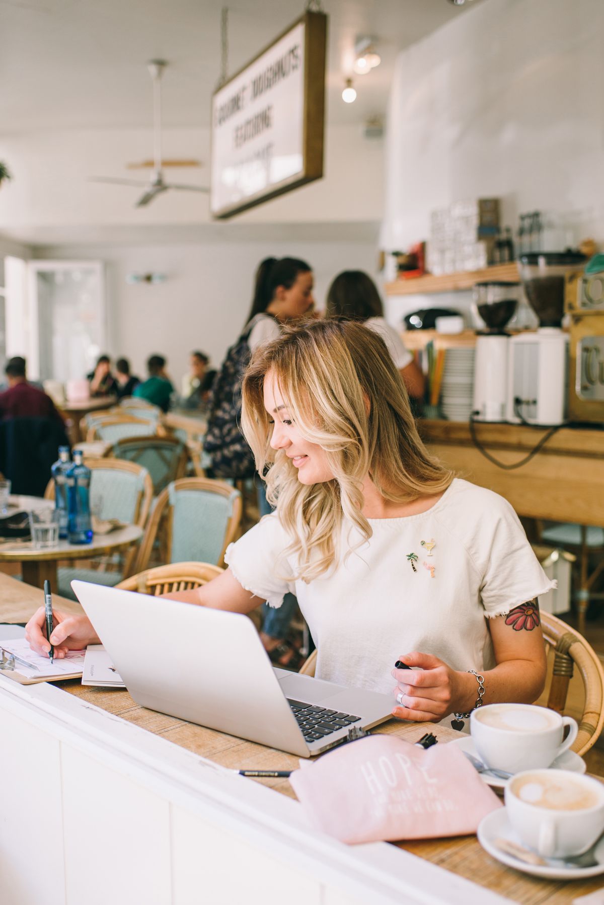 Proprietară de cafenea care lucrează la laptop, la tejghea