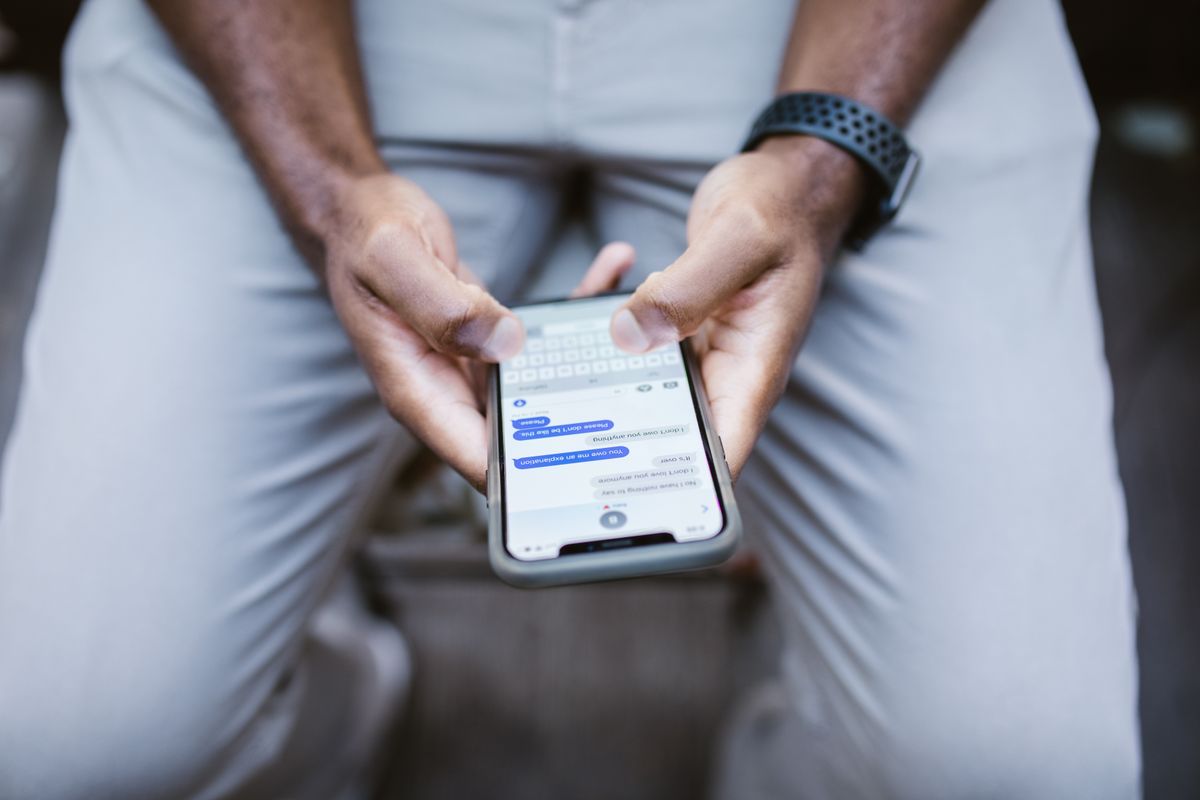 Mâini care scriu un mesaj pe telefon
