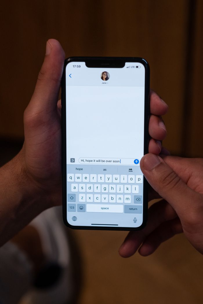 Mâini care țin un telefon cu o conversație deschisă